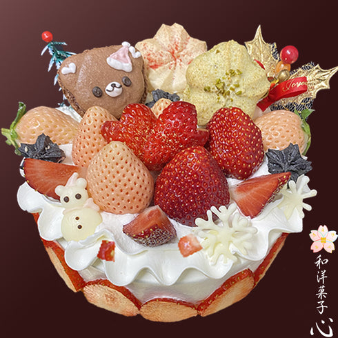 純生クリームの白いホールケーキに3色(赤、白、黒)の苺と、くまサンタのマカロン、苺とピスタチオの桜の形のマカロン、ホワイトチョコで手作りふるチョコレート細工の雪だるまや雪の結晶、柊やツリーなどが華やかに盛り付けられたスペシャルなケーキの画像。ケーキの側面にも苺が貼り付けられ、金粉をあしらって仕上げるどこにもない高級志向な特別なクリスマスケーキの写真。右下に和洋菓子心のロゴ。