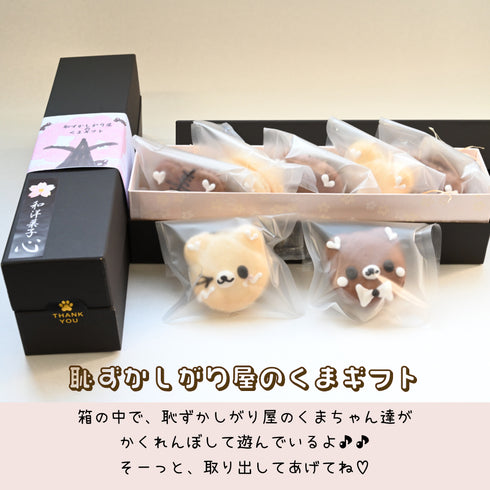 焦茶色のギフト箱に桜の木でくまちゃんがかくれんぼしている様子を描いた帯を巻いている。ギフトの中身とギフトがよくわかる画像。画像の下部に、恥ずかしがり屋のくまギフトの題名。その下に、箱や中で恥ずかしがり屋のくまちゃん達がかくれんぼしているよ♪ そーっと取り出してあげてね♪の文字。