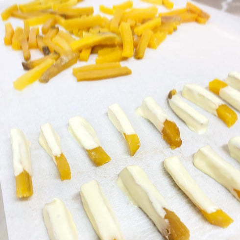 干し芋にホワイトチョコをコーティングしているところ