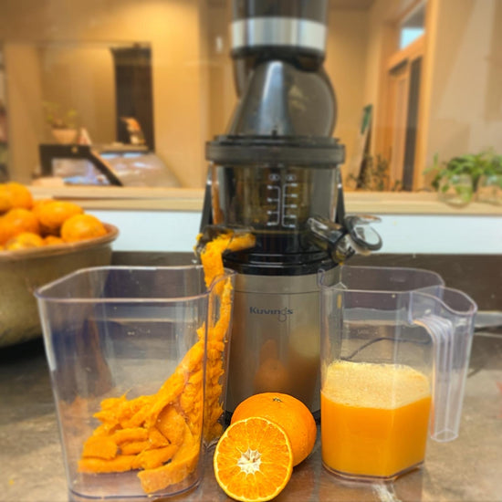 果汁100%生搾りジュースを作っているところ。和洋菓子心の店内をバックにした厨房内で調理している様子を撮影。業務用スロージューサーと柑橘、スロージューサーにかけて絞っているところを撮影した画像。