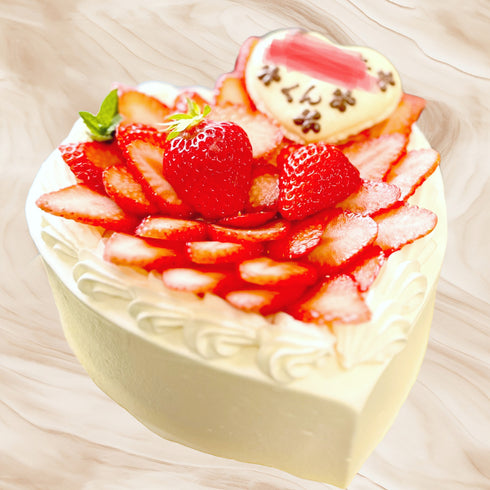 ハート型のアニバーサリーケーキ。純白の純生クリームと、真っ赤な苺のコントラストも可愛さをプラス。