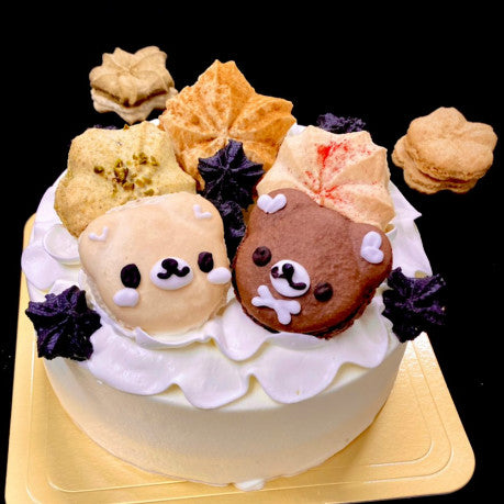 純生クリームの白いホールケーキの上に、自然派マカロンを飾って仕上げてある。マカロンは、和洋菓子心オリジナルの白くま、茶色いくま、季節の桜の形のマカロンが3つ、マカロンラスク。